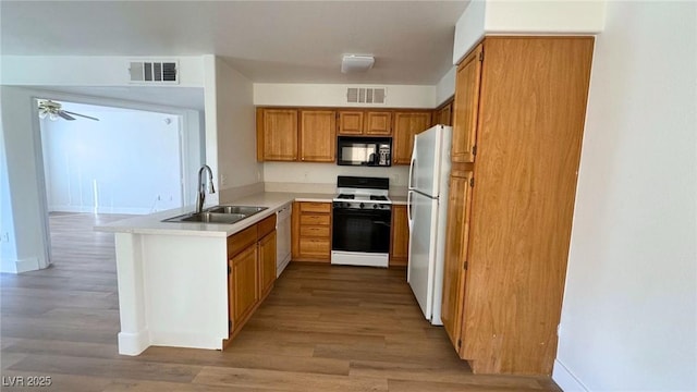 kitchen with ceiling fan, white appliances, sink, and light wood-type flooring