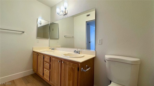 bathroom featuring vanity, hardwood / wood-style flooring, and toilet