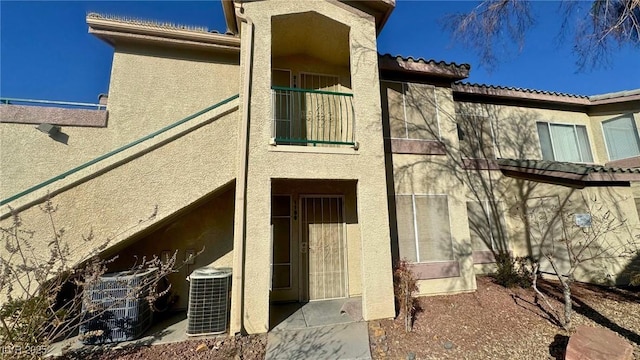 back of house with a balcony and central air condition unit