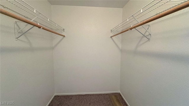 spacious closet featuring dark carpet