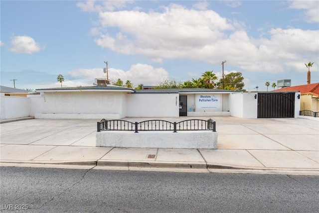 view of front of house with fence, a gate, and central air condition unit