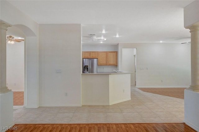 kitchen with stainless steel refrigerator with ice dispenser, ceiling fan, light brown cabinetry, and ornate columns