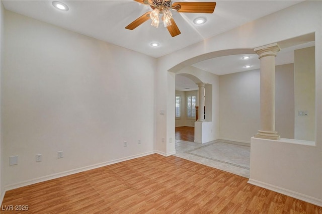 empty room featuring decorative columns, ceiling fan, and light hardwood / wood-style floors