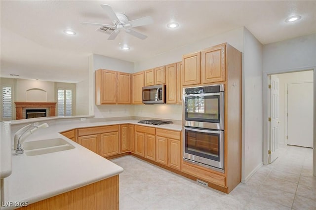 kitchen featuring sink, ceiling fan, stainless steel appliances, kitchen peninsula, and light brown cabinets