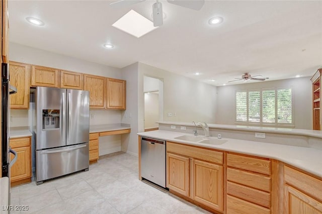 kitchen with stainless steel appliances, sink, light brown cabinetry, and ceiling fan