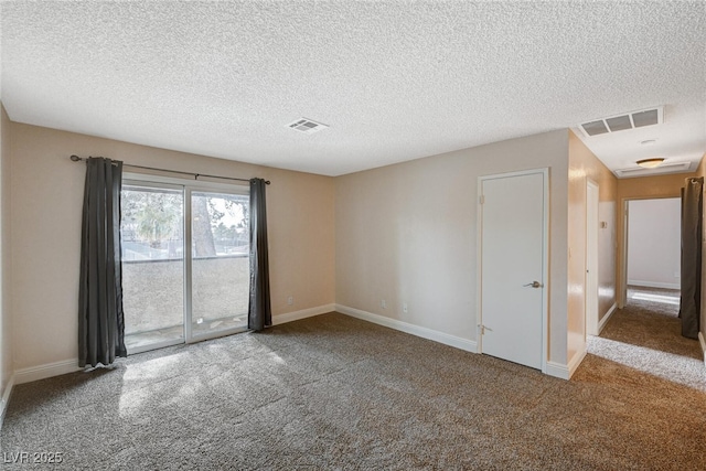 carpeted spare room featuring a textured ceiling