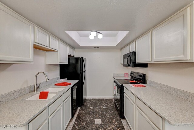 kitchen with sink, black appliances, a raised ceiling, and white cabinets