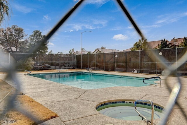 view of swimming pool with an in ground hot tub