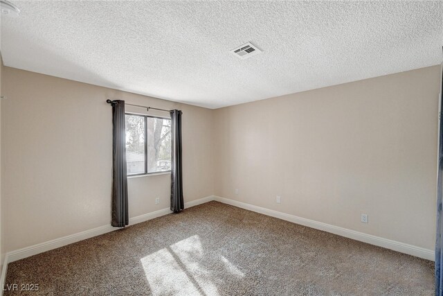 carpeted empty room with a textured ceiling