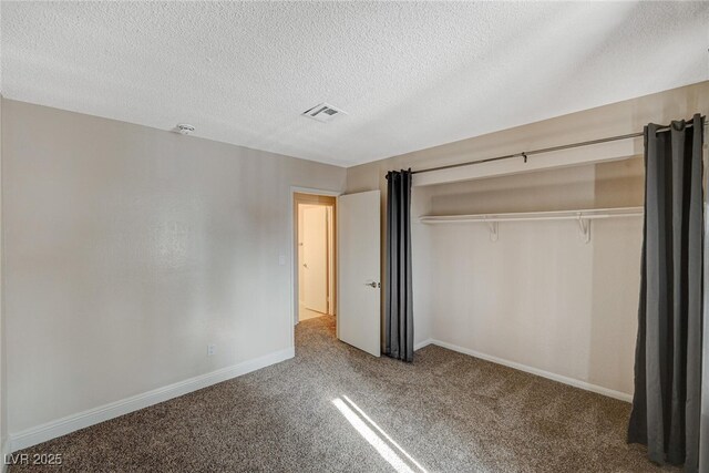 unfurnished bedroom with carpet flooring, a closet, and a textured ceiling