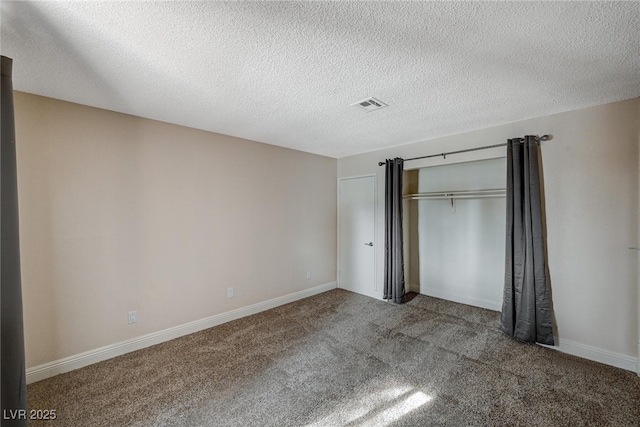 unfurnished bedroom with a closet, a textured ceiling, and carpet flooring