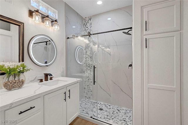 bathroom featuring an enclosed shower, vanity, and hardwood / wood-style flooring