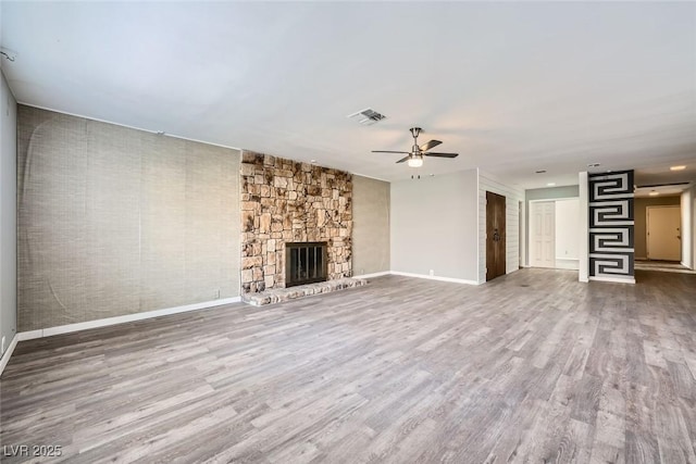 unfurnished living room with hardwood / wood-style flooring, ceiling fan, and a fireplace