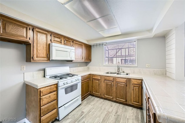 3954 Edgemoor Way, Las Vegas, NV 89121 - kitchen with white appliances, tile countertops, brown cabinets, and light wood-type flooring