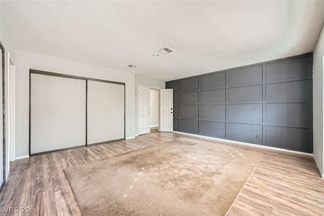 3954 Edgemoor Way, Las Vegas, NV 89121 - unfurnished bedroom with a decorative wall, wood finished floors, and a closet