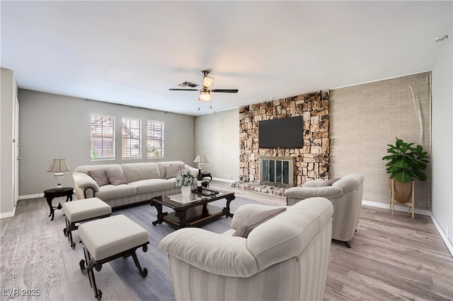 3954 Edgemoor Way, Las Vegas, NV 89121 - living area featuring a ceiling fan, a stone fireplace, and light wood-style flooring
