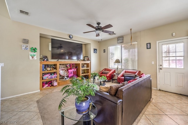 living room featuring plenty of natural light, light tile patterned floors, and ceiling fan