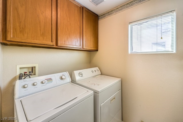 laundry room featuring washer and clothes dryer and cabinets