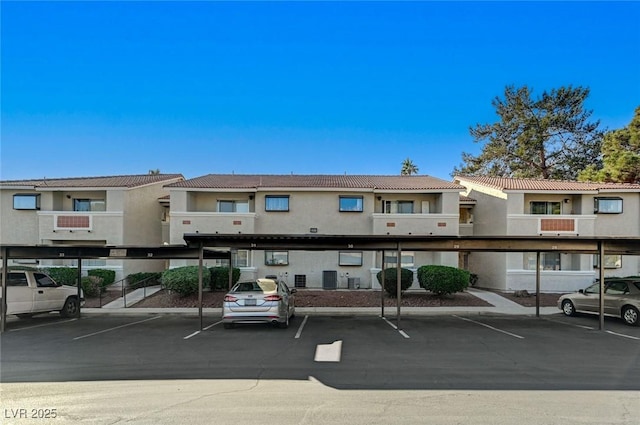 view of property with covered parking and central AC