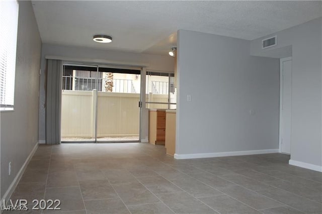 unfurnished room with a textured ceiling