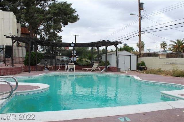 view of pool with a shed and a pergola