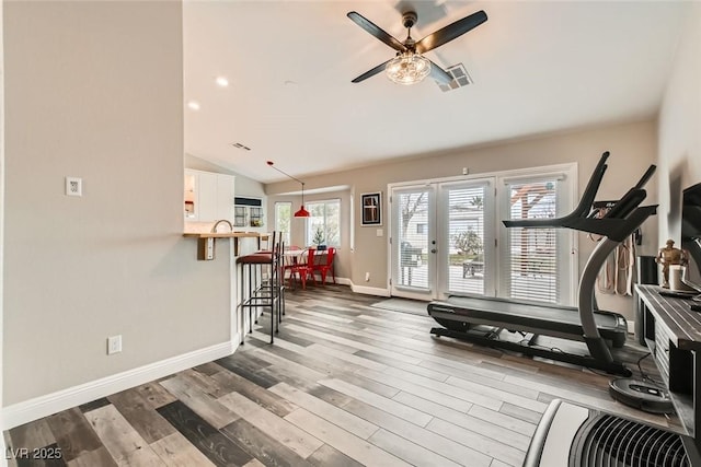 workout room with hardwood / wood-style flooring, vaulted ceiling, and ceiling fan