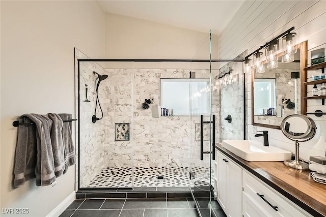 bathroom with vanity, tile patterned flooring, vaulted ceiling, and walk in shower