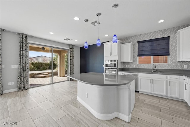 kitchen with sink, pendant lighting, and white cabinets