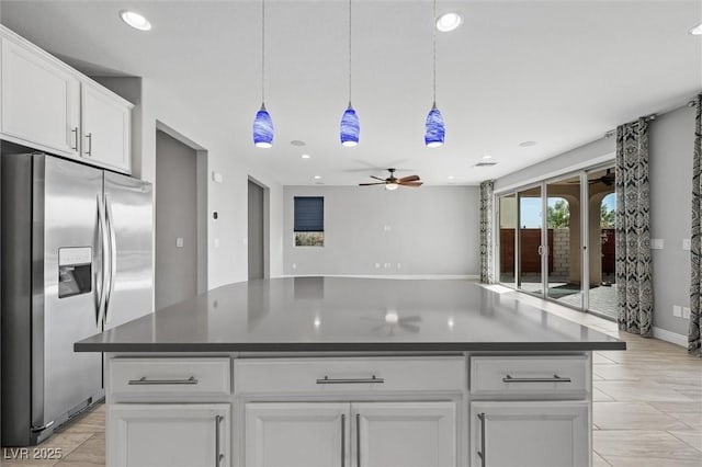 kitchen with pendant lighting, stainless steel fridge, a center island, and white cabinets