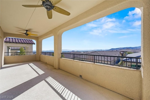 view of patio / terrace with a balcony, a mountain view, and ceiling fan