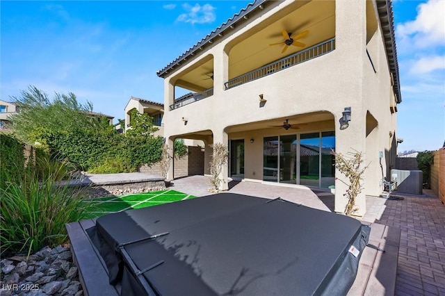 rear view of house featuring ceiling fan, a balcony, a patio area, and cooling unit