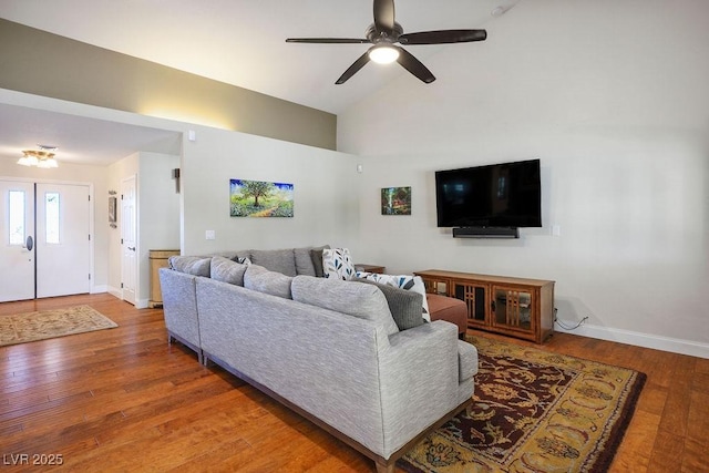 living room featuring hardwood / wood-style floors, high vaulted ceiling, and ceiling fan