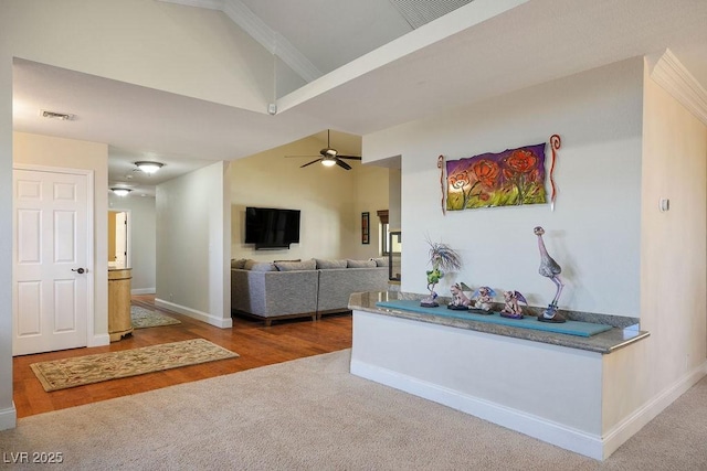 living room featuring hardwood / wood-style flooring, ceiling fan, crown molding, and high vaulted ceiling