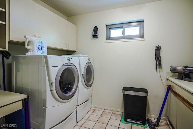 laundry room featuring light tile patterned flooring, cabinets, and washer and clothes dryer