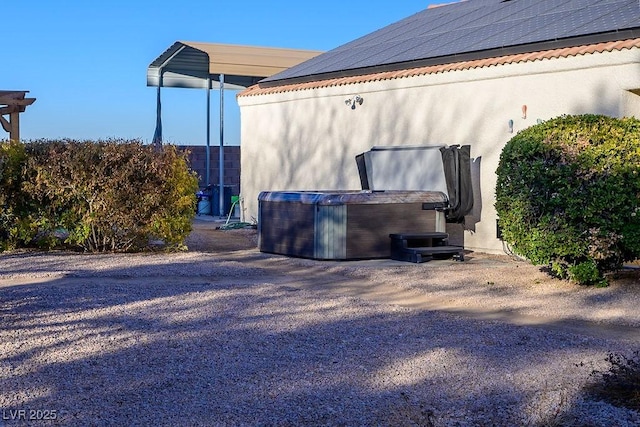 view of property exterior featuring a hot tub and solar panels