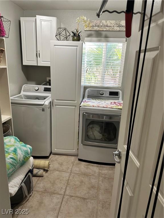 laundry room featuring cabinets, washing machine and dryer, and light tile patterned floors