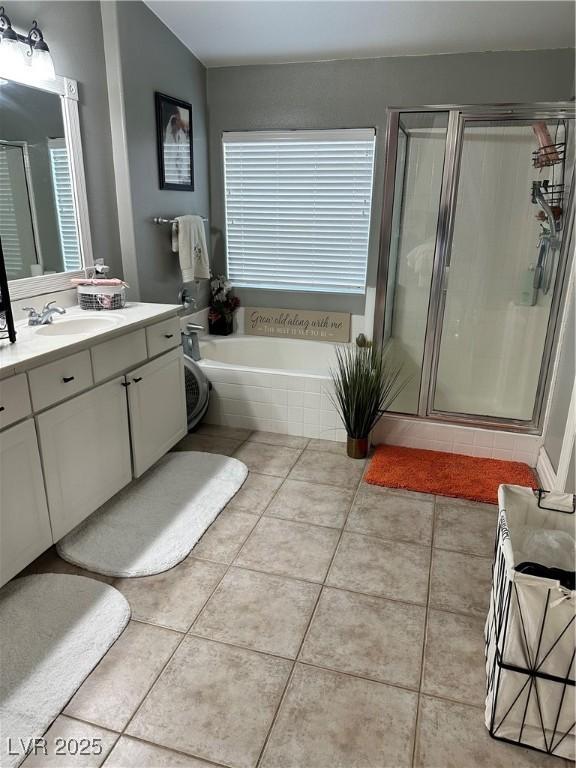 bathroom featuring vanity, shower with separate bathtub, and tile patterned floors