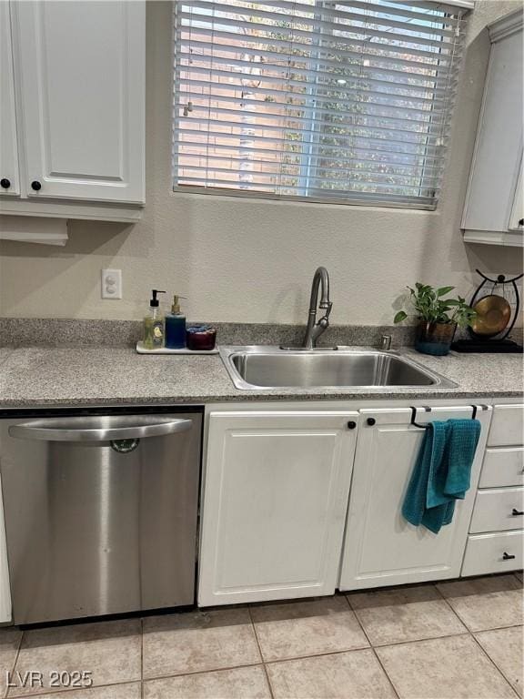 kitchen with a healthy amount of sunlight, sink, stainless steel dishwasher, and white cabinets