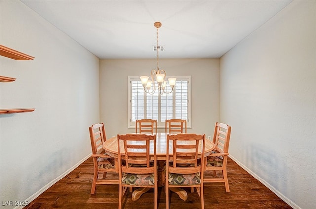 dining room featuring dark wood-type flooring and a notable chandelier