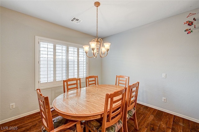 dining room with dark hardwood / wood-style flooring and a chandelier