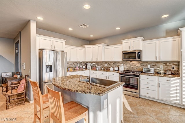 kitchen featuring stone countertops, appliances with stainless steel finishes, sink, and white cabinets