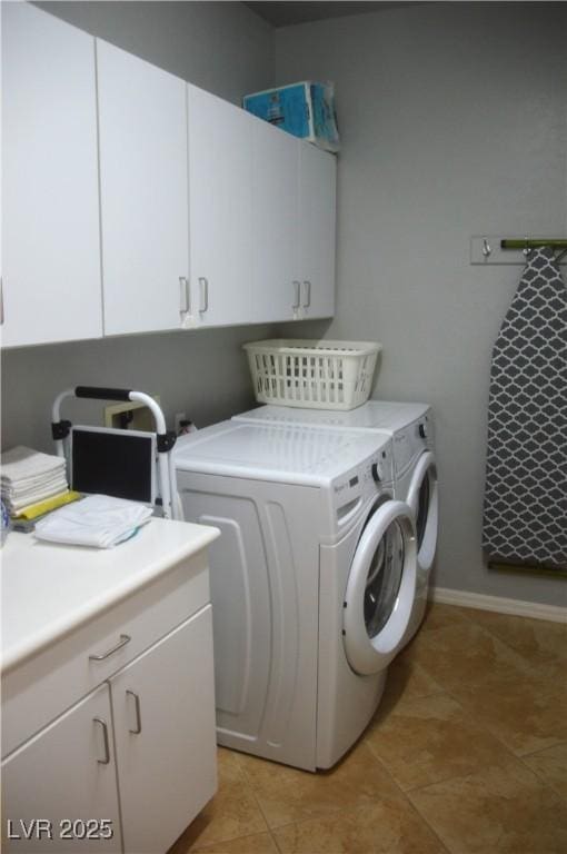 clothes washing area with cabinets and washing machine and clothes dryer