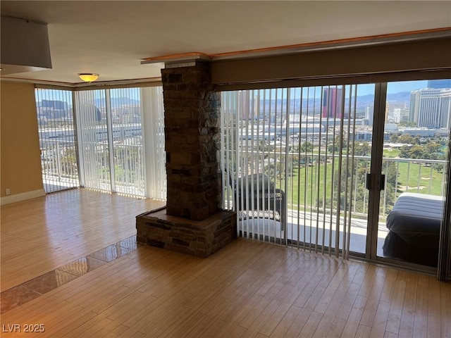 unfurnished living room with a wall of windows, a healthy amount of sunlight, and hardwood / wood-style floors