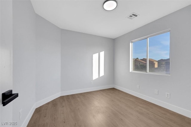 unfurnished room with hardwood / wood-style floors and plenty of natural light