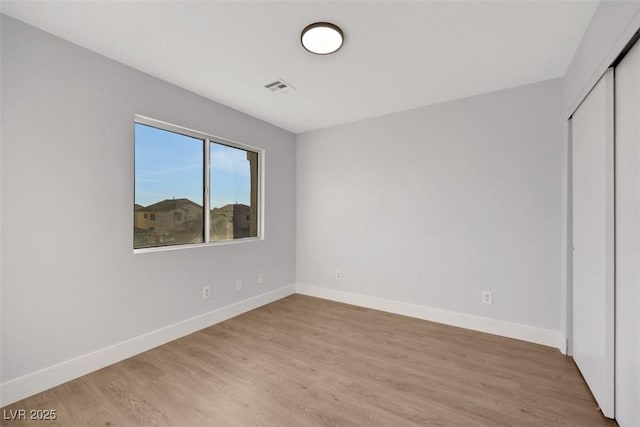 unfurnished bedroom with light hardwood / wood-style floors and a closet