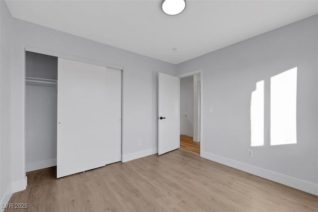 unfurnished bedroom with a closet and light wood-type flooring