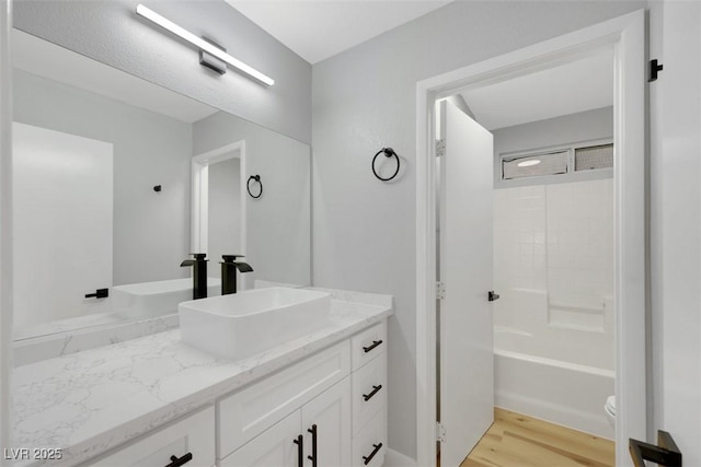 full bathroom with vanity, wood-type flooring, toilet, and shower / bath combination