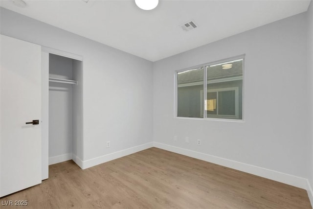 unfurnished bedroom featuring a closet and light wood-type flooring