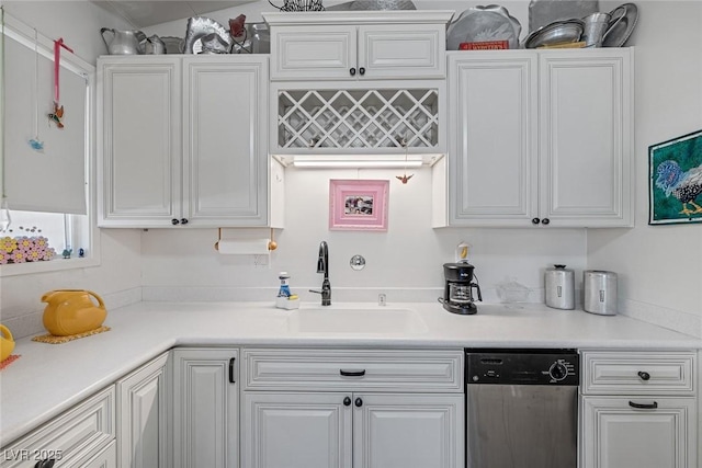 kitchen featuring sink, white cabinets, and dishwasher