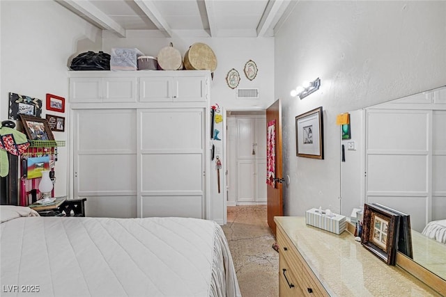 bedroom with beam ceiling and light colored carpet